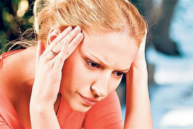 Женщина держится руками за голову